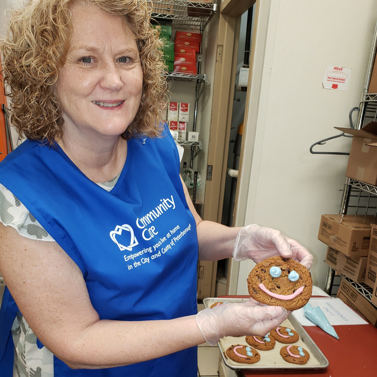 Patty Tipton volunteering with Community Care Peterborough, decorating cookies for a fundraising campaign.