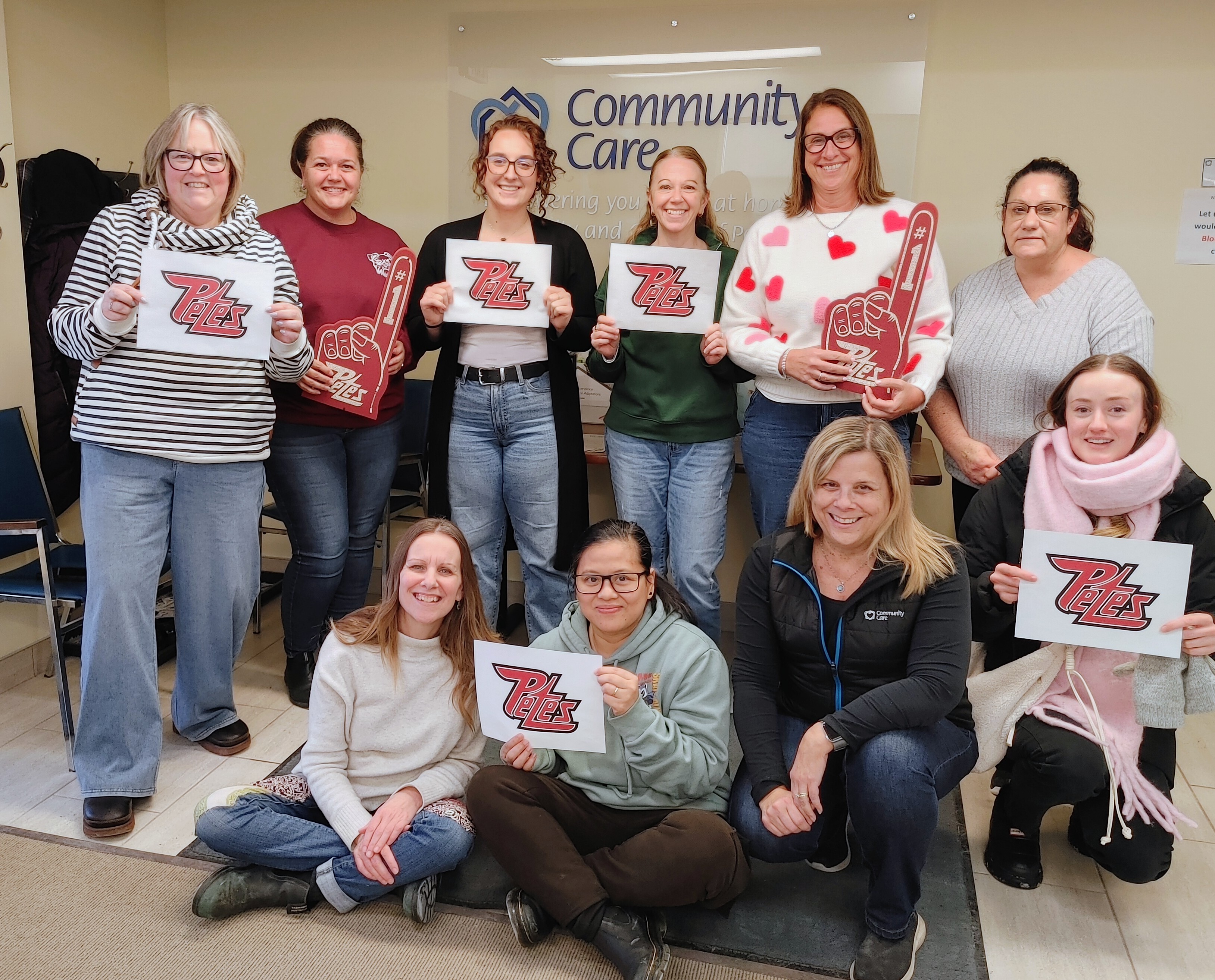 Staff at Community Care holding Petes signs